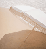 white beach umbrella with tassels
